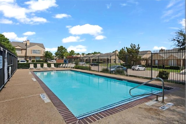 community pool with fence and a residential view