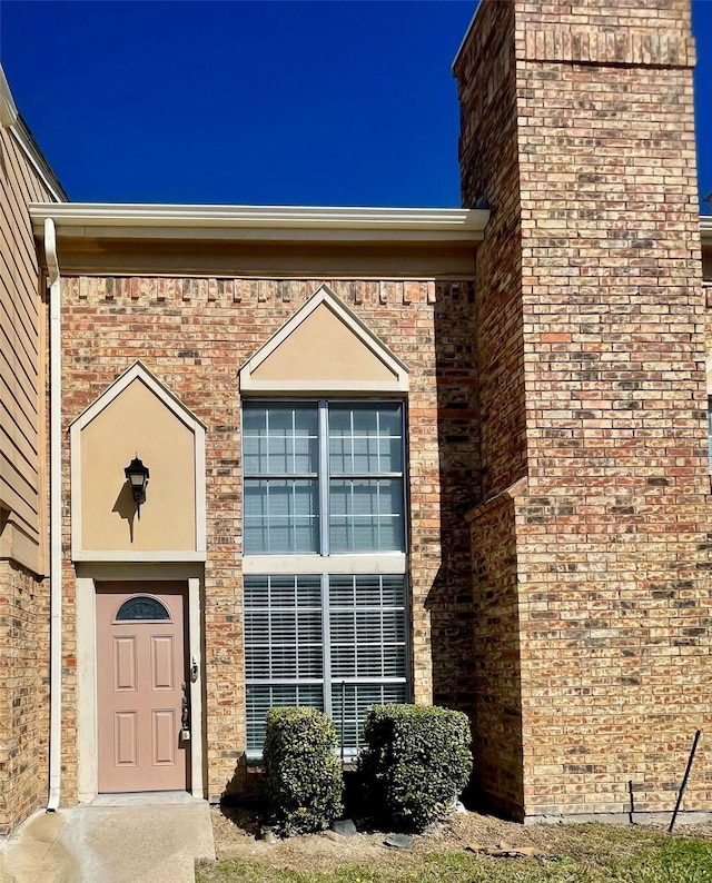 doorway to property with brick siding