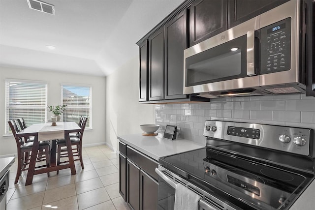 kitchen featuring stainless steel appliances, tasteful backsplash, light countertops, visible vents, and light tile patterned flooring