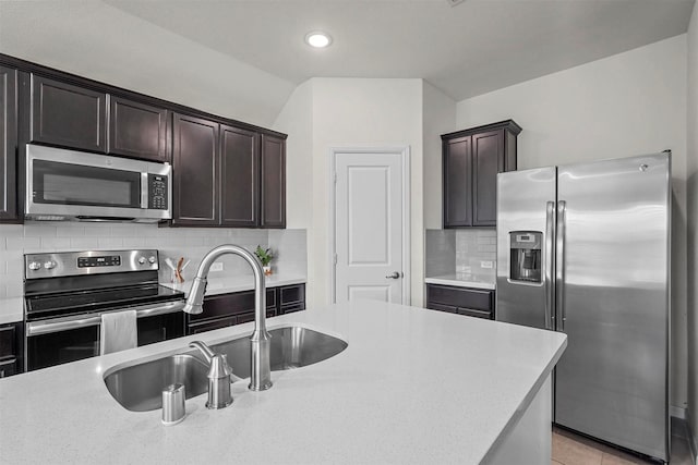 kitchen featuring dark brown cabinetry, recessed lighting, a sink, appliances with stainless steel finishes, and tasteful backsplash