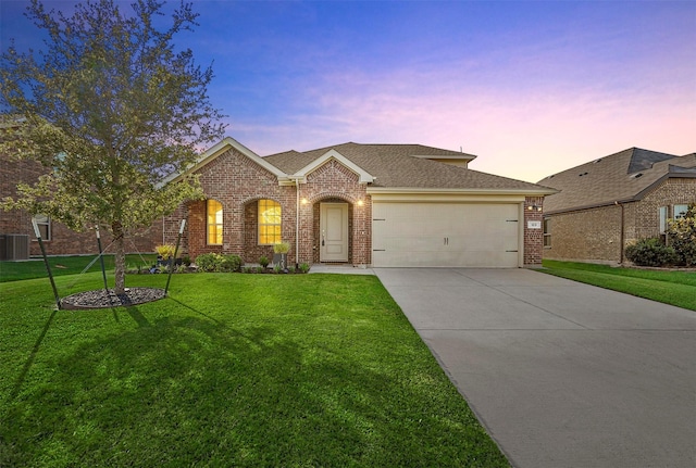 view of front of home with a garage, concrete driveway, a lawn, and brick siding