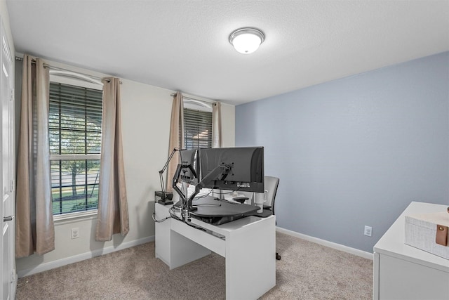 office area with baseboards, a textured ceiling, and light colored carpet