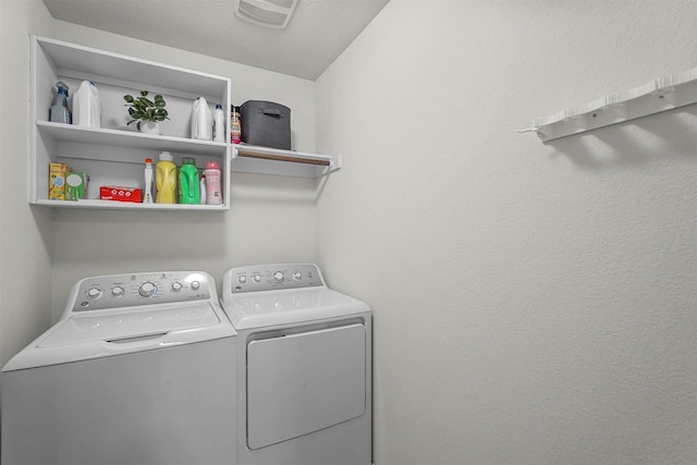 clothes washing area featuring laundry area, washing machine and clothes dryer, and visible vents