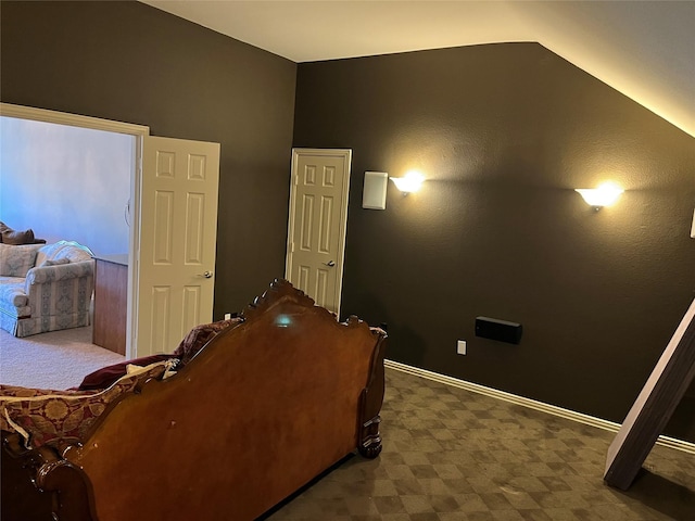 bedroom with lofted ceiling and baseboards