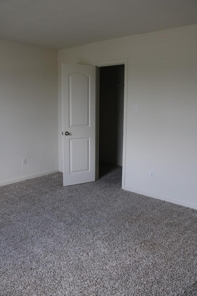 carpeted spare room featuring baseboards