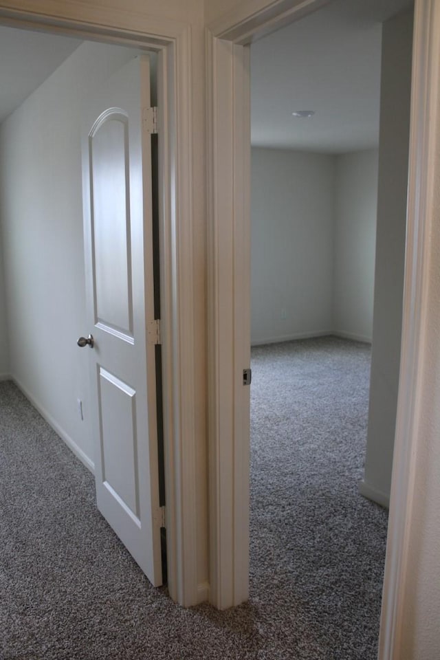 hallway with carpet floors and baseboards