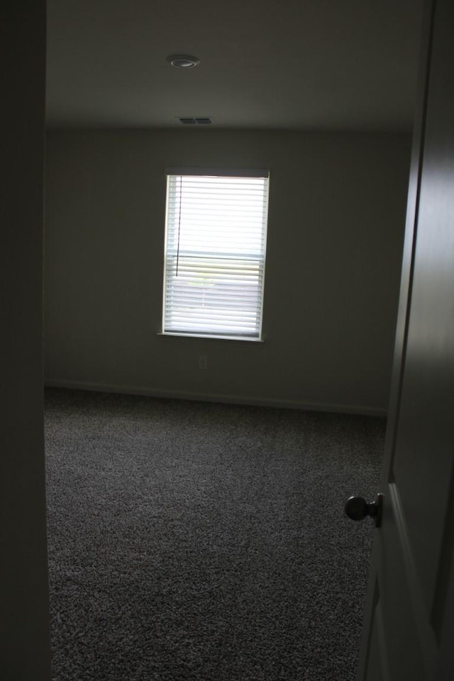 unfurnished room with carpet floors, baseboards, and visible vents