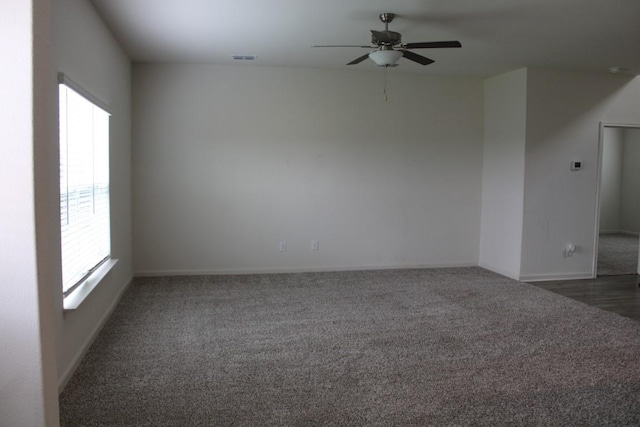 empty room featuring carpet, visible vents, and a ceiling fan