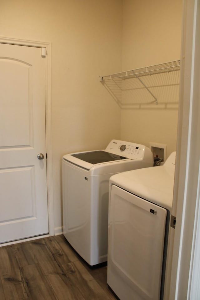 clothes washing area with laundry area, dark wood-type flooring, and washer and clothes dryer