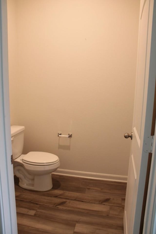 bathroom featuring baseboards, toilet, and wood finished floors