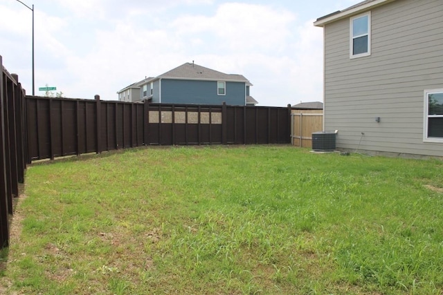 view of yard with a fenced backyard and central air condition unit