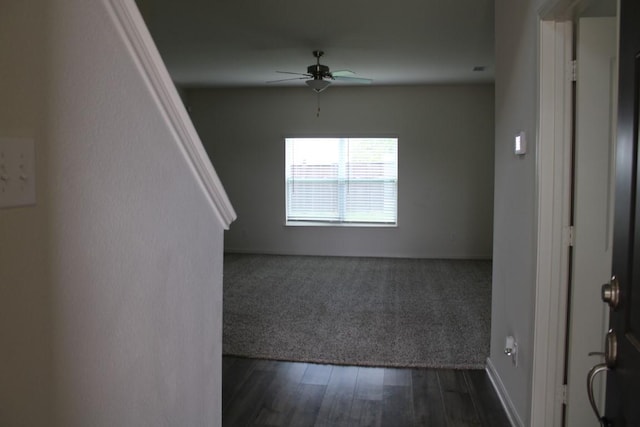 empty room with ceiling fan and dark wood-type flooring