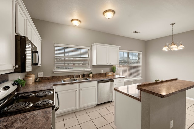 kitchen featuring stainless steel appliances, a sink, visible vents, white cabinets, and dark countertops