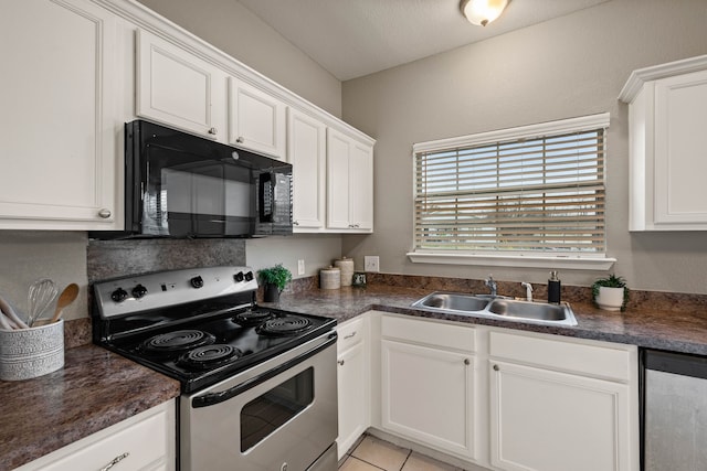 kitchen with dark countertops, white cabinetry, stainless steel appliances, and a sink