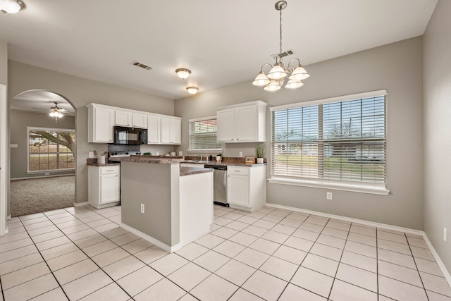 kitchen with arched walkways, black microwave, white cabinetry, stainless steel dishwasher, and dark countertops