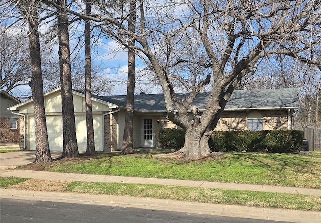 view of front facade with a garage, concrete driveway, a shingled roof, and a front lawn