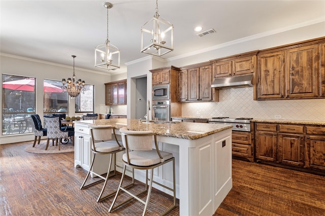 kitchen with visible vents, a kitchen island with sink, stainless steel appliances, decorative backsplash, and under cabinet range hood