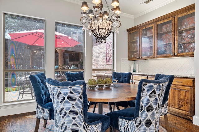 dining space featuring dark wood-style floors, visible vents, ornamental molding, and a chandelier