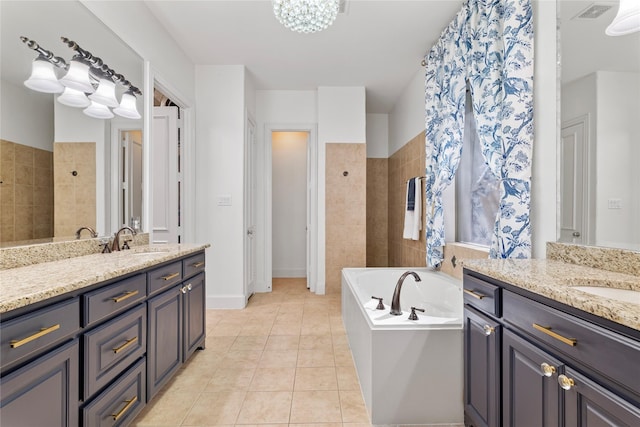 full bathroom featuring tile patterned flooring, visible vents, two vanities, and a sink