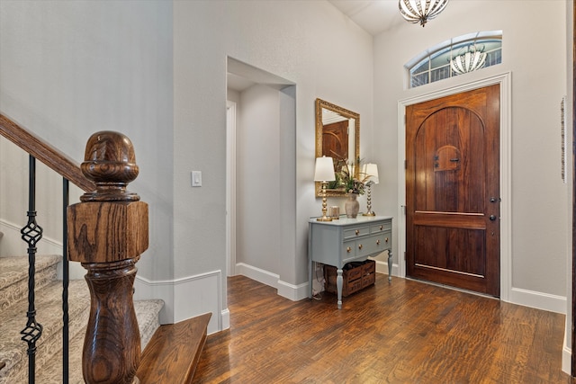 foyer featuring dark wood finished floors, stairway, and baseboards