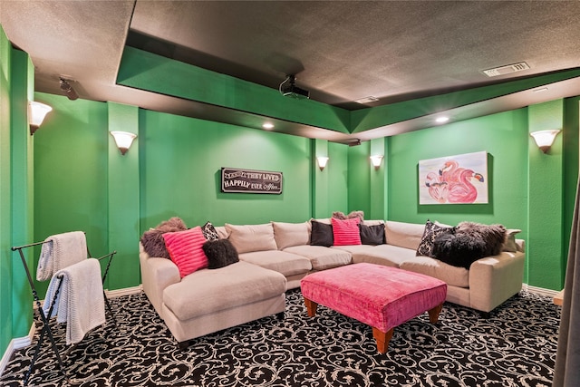 carpeted home theater featuring visible vents, baseboards, and a textured ceiling