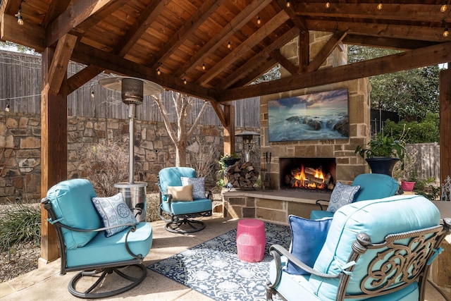 view of patio / terrace with a gazebo, an outdoor living space with a fireplace, and fence