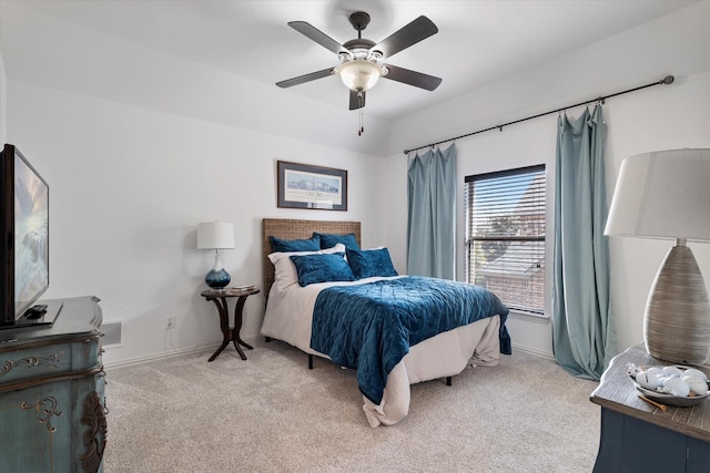 bedroom with visible vents, light colored carpet, baseboards, and ceiling fan