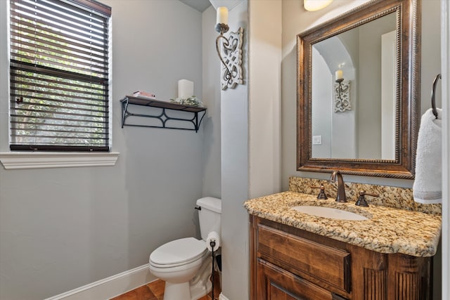 bathroom featuring baseboards, toilet, and vanity