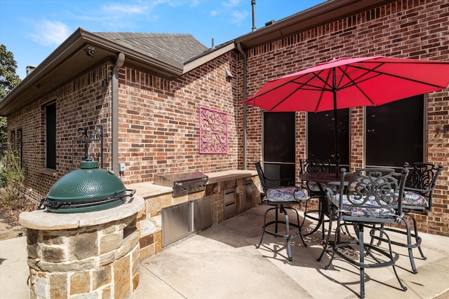 view of patio featuring outdoor dining space, a grill, and exterior kitchen