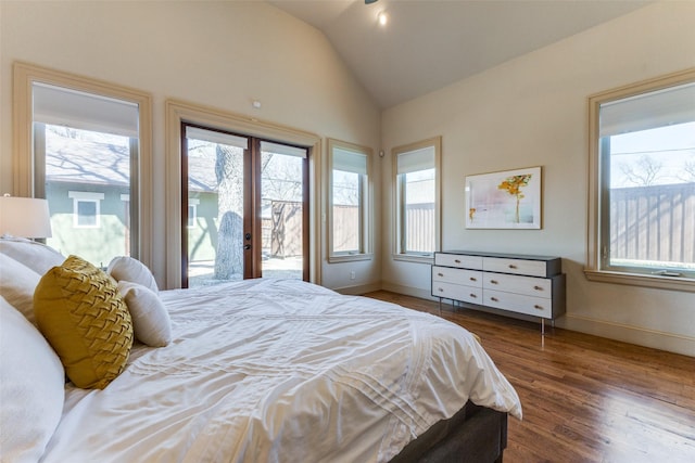 bedroom featuring vaulted ceiling, access to outside, wood finished floors, and baseboards