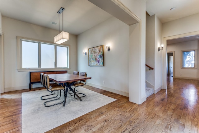 dining space featuring stairs, baseboards, and wood finished floors