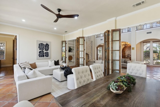 dining area with arched walkways, ceiling fan with notable chandelier, visible vents, and crown molding