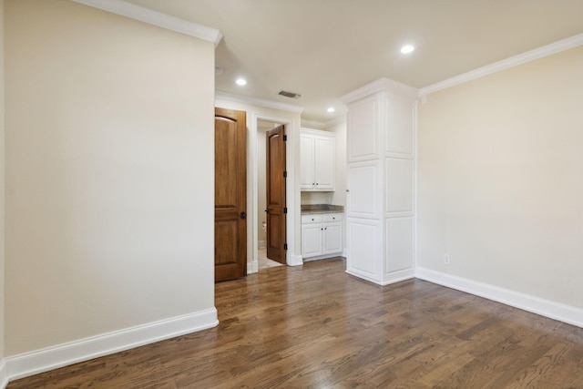 unfurnished room with visible vents, baseboards, dark wood finished floors, ornamental molding, and recessed lighting