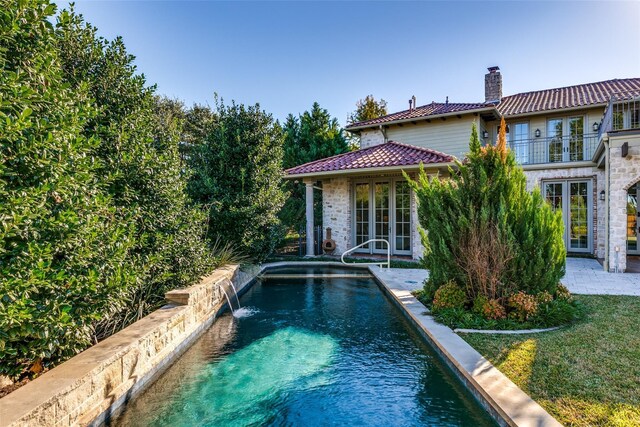 outdoor pool featuring french doors and a patio area