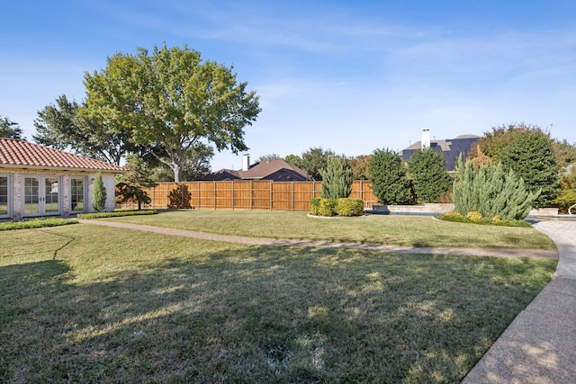 view of yard with fence and french doors