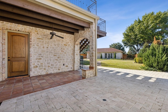 view of patio with a balcony and a ceiling fan