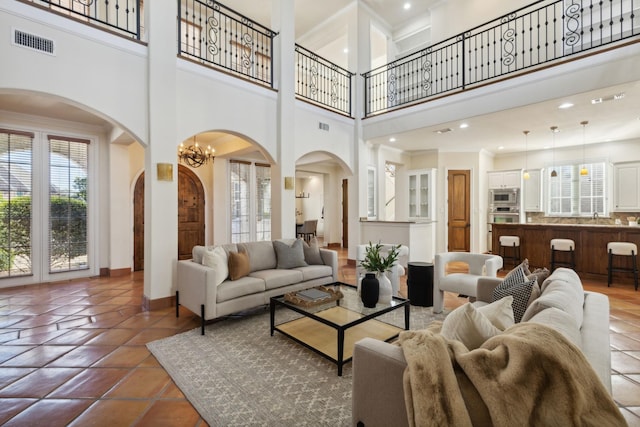 tiled living area with a wealth of natural light, visible vents, and baseboards