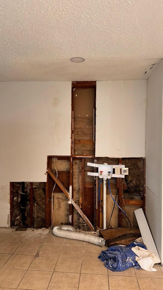 misc room with a textured ceiling and tile patterned flooring