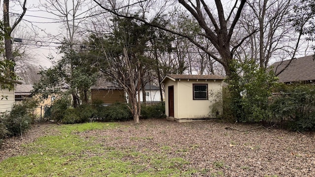 view of yard featuring an outbuilding, a shed, and fence