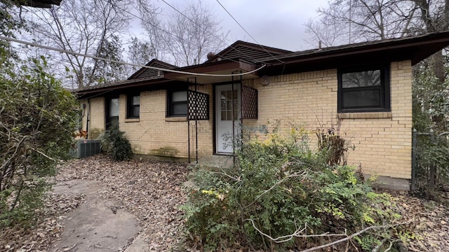 view of front of house featuring central AC and brick siding