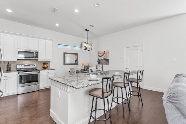 kitchen featuring light stone countertops, appliances with stainless steel finishes, dark wood-style flooring, and a sink