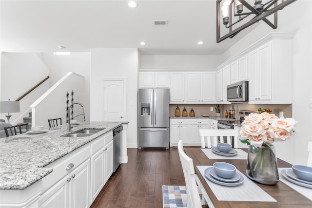 kitchen featuring dark wood-style floors, visible vents, appliances with stainless steel finishes, white cabinets, and a sink