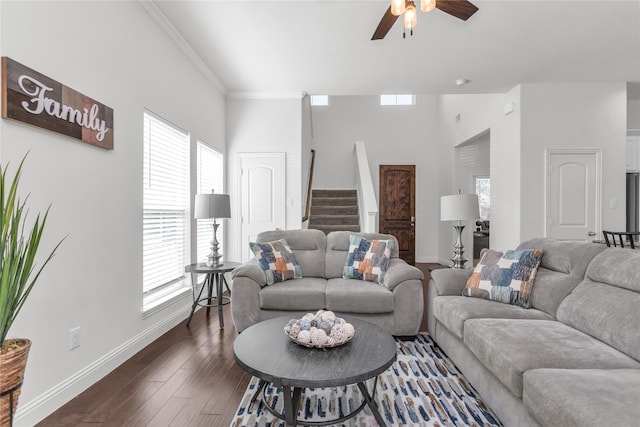 living room featuring dark wood-style floors, ornamental molding, ceiling fan, baseboards, and stairs