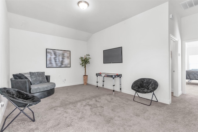 sitting room with lofted ceiling, carpet, visible vents, and baseboards