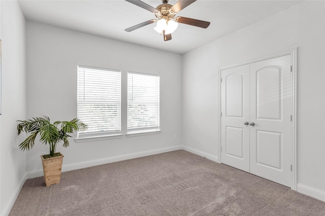 empty room with a ceiling fan, carpet flooring, and baseboards