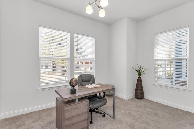 home office featuring baseboards, plenty of natural light, an inviting chandelier, and light colored carpet