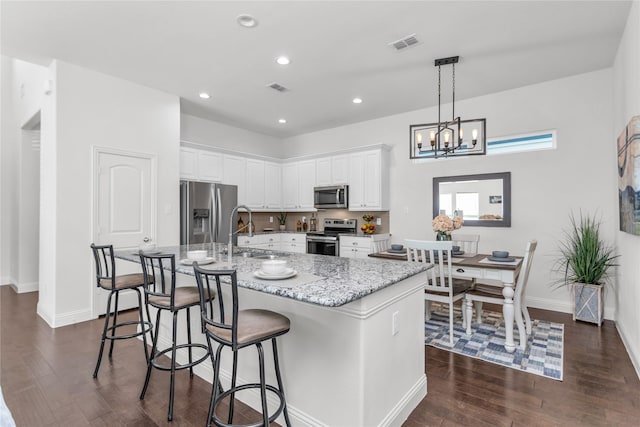 kitchen featuring a sink, visible vents, white cabinets, appliances with stainless steel finishes, and dark wood finished floors