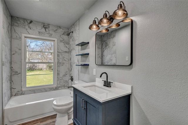 bathroom featuring shower / washtub combination, a textured wall, toilet, vanity, and wood finished floors