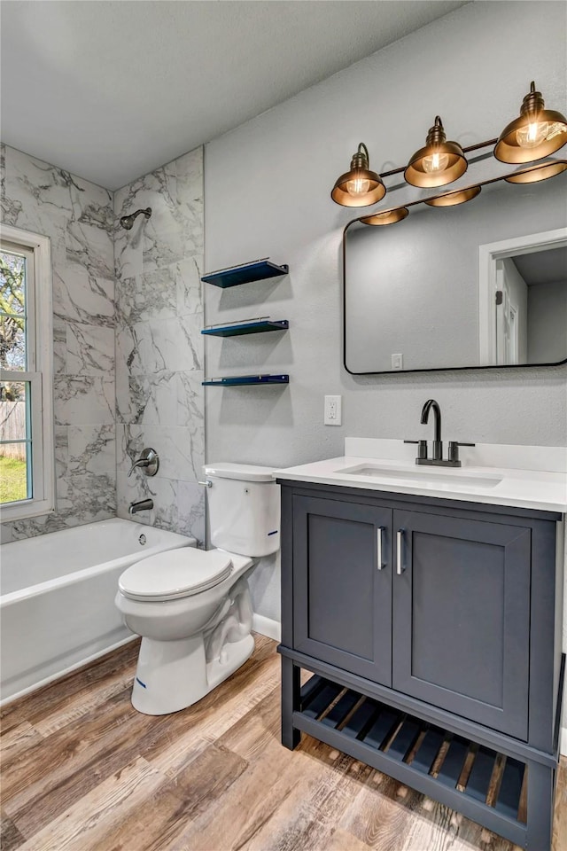 full bath featuring toilet, shower / washtub combination, wood finished floors, and vanity