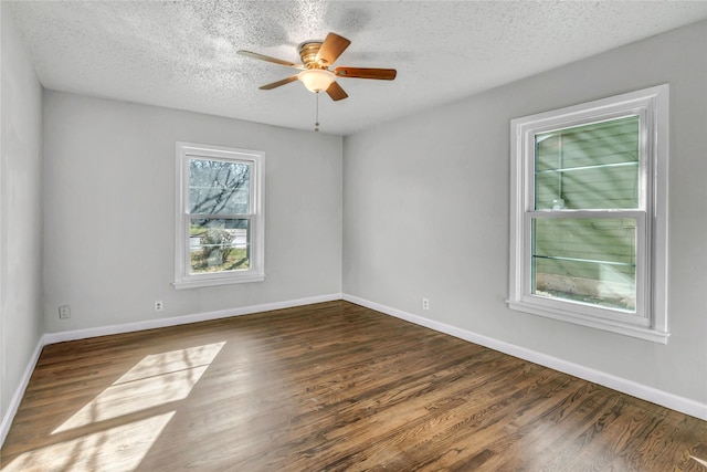 unfurnished room with a textured ceiling, wood finished floors, a ceiling fan, and baseboards